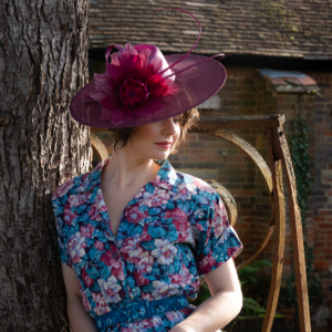 magenta percher boater hat with large feather flower